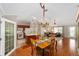 Open-concept dining area features hardwood floors and elegant chandelier, seamlessly flowing into the living room at 3041 Batally Ct, The Villages, FL 32162