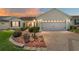 Charming single-story home featuring a paved driveway, manicured landscaping, and a two-car garage at 3041 Batally Ct, The Villages, FL 32162