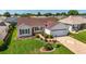 Aerial view of the home's manicured lawn, brick driveway, and lovely landscaping at 3041 Batally Ct, The Villages, FL 32162