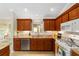 Well-lit kitchen with white appliances, granite countertops, and classic cabinetry for efficient meal prep at 3041 Batally Ct, The Villages, FL 32162