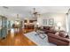 Spacious living room with a ceiling fan, hardwood floors, and views into the dining and kitchen areas at 3041 Batally Ct, The Villages, FL 32162