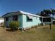 Rear side exterior view of a home with lawn and trees at 323 Hawthorne Blvd, Leesburg, FL 34748