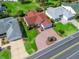 Aerial view featuring a well-maintained home with a red roof and brick driveway in a tidy neighborhood at 3266 Woodridge Dr, The Villages, FL 32162