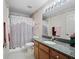 Bathroom with a granite countertop, sink, and patterned wallpaper at 3266 Woodridge Dr, The Villages, FL 32162