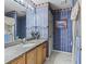 Bathroom with granite countertop and decorative wallpaper at 3266 Woodridge Dr, The Villages, FL 32162