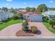 Aerial view of the single-Gathering home with a brick driveway and well-manicured landscaping at 3266 Woodridge Dr, The Villages, FL 32162