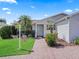 Charming home featuring a well-manicured lawn, brick walkway, and mature landscaping at 3266 Woodridge Dr, The Villages, FL 32162