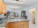 Kitchen featuring granite countertops and oak cabinets that seamlessly flow into the dining and living areas at 3266 Woodridge Dr, The Villages, FL 32162