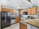Traditional style kitchen with oak cabinets, granite countertops, tile backsplash, and modern black appliances at 3266 Woodridge Dr, The Villages, FL 32162
