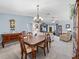 Open-concept living room with a ceiling fan, and a view of the dining area and sunroom at 3266 Woodridge Dr, The Villages, FL 32162