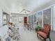 Bright sunroom featuring a ceiling fan, large windows, and comfortable seating area at 3266 Woodridge Dr, The Villages, FL 32162