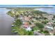 High-angle aerial view of lakefront houses, private docks, and verdant trees along the waterfront, showcasing lakeside beauty at 33620 Picciola Dr, Fruitland Park, FL 34731