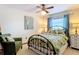 Cozy bedroom features tropical themed bed, ceiling fan, and comfortable green chair at 33620 Picciola Dr, Fruitland Park, FL 34731