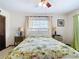 Bright bedroom featuring a white bed frame, tropical bedding, and matching side tables at 33620 Picciola Dr, Fruitland Park, FL 34731