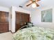 View of the bedroom featuring tropical bedding, wooden closet, and matching chair at 33620 Picciola Dr, Fruitland Park, FL 34731