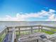 Waterfront deck features weathered wood, built-in bench seating, and solar lights for a tranquil lakeside relaxation and stunning views at 33620 Picciola Dr, Fruitland Park, FL 34731