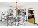 An elegant dining room with decorative chandelier, glass table, and views of the kitchen at 33620 Picciola Dr, Fruitland Park, FL 34731