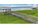 Wooden dock with a boat lift and platform extending into the lake, perfect for waterfront enjoyment and recreational activities at 33620 Picciola Dr, Fruitland Park, FL 34731