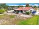 Rear view of a home featuring a red tile roof, screened in porch, and a large grassy yard at 33620 Picciola Dr, Fruitland Park, FL 34731