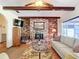 Inviting living room showcasing a brick fireplace, exposed beams, and natural lighting at 33620 Picciola Dr, Fruitland Park, FL 34731