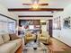 Bright living room with wood floors and accents, leading to a sunroom and open to the adjacent kitchen at 33620 Picciola Dr, Fruitland Park, FL 34731