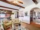 Open-concept living room showcasing wood beams, wood floors, and access to the kitchen and front entry at 33620 Picciola Dr, Fruitland Park, FL 34731