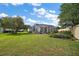 Expansive backyard with screened-in pool, beautiful lawn, and mature trees at 342 Mccormick Ln, The Villages, FL 32162