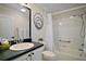 Well-maintained bathroom with black countertop, tub/shower combo, and modern fixtures at 342 Mccormick Ln, The Villages, FL 32162