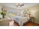 Comfortable bedroom with hardwood floors, ceiling fan, and a sun-filled window view at 342 Mccormick Ln, The Villages, FL 32162
