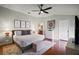 Cozy bedroom with hardwood floors, ceiling fan, accent wall art, and a ensuite bath at 342 Mccormick Ln, The Villages, FL 32162
