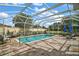 Inviting pool area with a screened enclosure, comfortable seating, and a lush green landscape in the background at 342 Mccormick Ln, The Villages, FL 32162