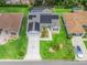 Stunning aerial view of a home with solar panels, a screened-in pool, a driveway, and meticulously manicured landscaping at 3534 Auburndale Ave, The Villages, FL 32162