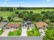 Beautiful aerial view of a home featuring well-maintained landscaping, solar panels, and a lovely green field in the background at 3534 Auburndale Ave, The Villages, FL 32162