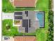 Aerial view of house showcasing solar panels, screened-in pool, and landscaped yard at 3534 Auburndale Ave, The Villages, FL 32162