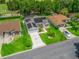 Aerial view of house with solar panels, screened-in pool, landscaping, and long driveway at 3534 Auburndale Ave, The Villages, FL 32162