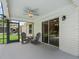 View of a relaxing covered and screened back porch featuring rocking chairs and ceiling fan at 3534 Auburndale Ave, The Villages, FL 32162