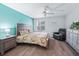 A well-lit bedroom with a light teal accent wall and hardwood flooring at 3534 Auburndale Ave, The Villages, FL 32162