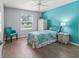 Bright bedroom featuring a decorative bed, a window, light walls and wood floor at 3534 Auburndale Ave, The Villages, FL 32162