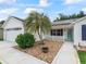 Home featuring a well-maintained lawn, solar panels, palm tree, and a charming front entryway at 3534 Auburndale Ave, The Villages, FL 32162