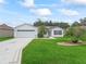 Charming one-story home featuring a well-manicured lawn, pristine driveway, and inviting curb appeal at 3534 Auburndale Ave, The Villages, FL 32162