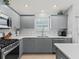 Well-lit kitchen with stainless steel appliances and modern gray cabinetry at 3534 Auburndale Ave, The Villages, FL 32162