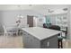 Bright kitchen with a central island, gray cabinetry, and views of the dining area at 3534 Auburndale Ave, The Villages, FL 32162
