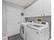 Laundry room with white cabinets, new washer and dryer, and neutral walls at 3534 Auburndale Ave, The Villages, FL 32162