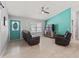 Bright living room featuring tile flooring, a teal accent wall, and comfortable seating with a ceiling fan at 3534 Auburndale Ave, The Villages, FL 32162