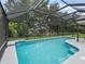 Beautiful screened-in pool with lush green trees and a serene backyard view at 3534 Auburndale Ave, The Villages, FL 32162
