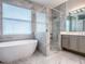 Spa-like bathroom featuring a soaking tub, glass-enclosed shower, and modern vanity at 3775 Brantley Place Cir, Apopka, FL 32703