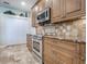 Well-lit kitchen featuring granite countertops, wooden cabinetry, and stainless steel appliances at 3775 Brantley Place Cir, Apopka, FL 32703