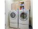 Modern laundry room with stacked washer and dryer, with shelving offering ample storage space at 3775 Brantley Place Cir, Apopka, FL 32703