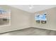 A bright bedroom with gray floors and two windows at 3842 Beacon Ridge Way, Clermont, FL 34711