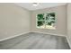 Modern bedroom with wood-look floors and large window at 3842 Beacon Ridge Way, Clermont, FL 34711